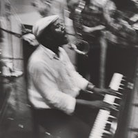 a man playing a keyboard in front of a group of people